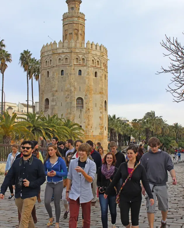 A group of students walk past a Spanish tower